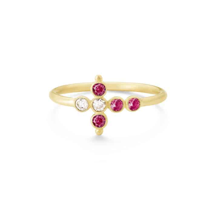A gold-colored ring featuring a geometric design with red and clear stones set around its circumference.