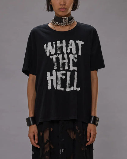 Person wearing a black t-shirt with 'WHAT THE HELL' text on a gray background